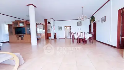 Spacious open-plan living and dining area with elegant wooden furniture and bright natural lighting.