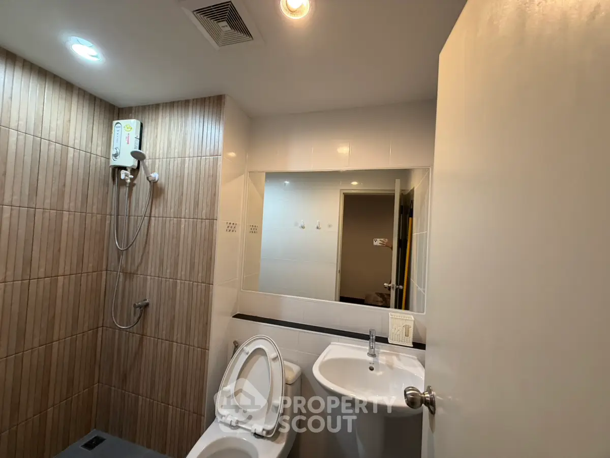Modern bathroom with shower and sleek fixtures in contemporary apartment.
