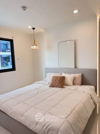 Cozy modern bedroom with stylish decor and ample natural light, perfect for relaxation and comfort.