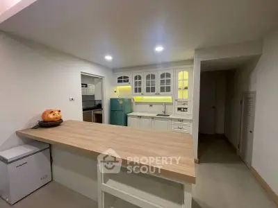 Charming kitchen with open layout and vintage fridge, perfect for cozy gatherings.