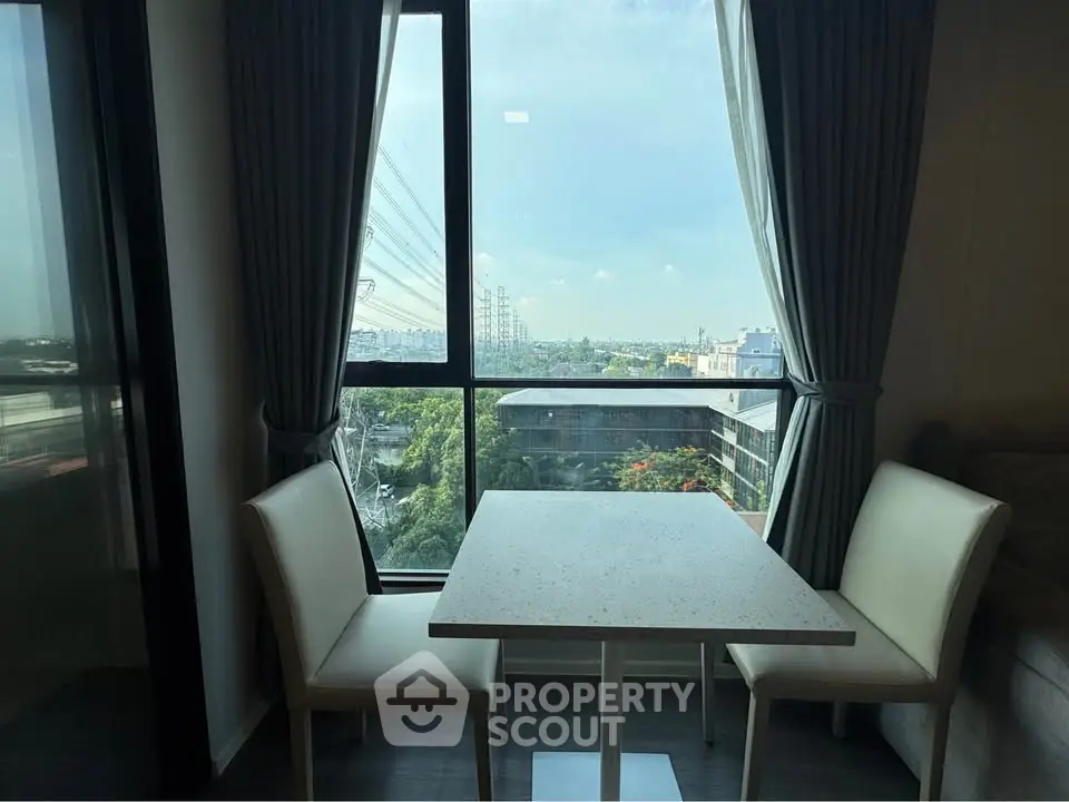 Charming dining nook with a stunning city view through large windows, perfect for cozy meals.
