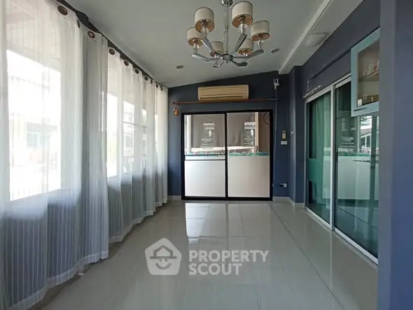 Spacious sunlit room with large windows and modern lighting, perfect for versatile use.