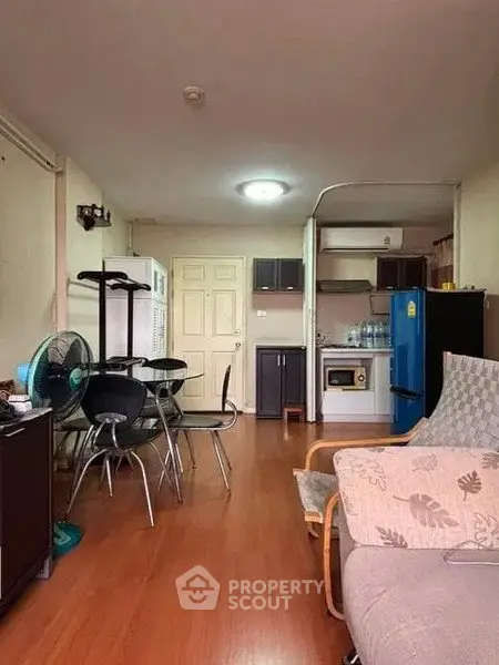Cozy living room with dining area and compact kitchen in open layout apartment.