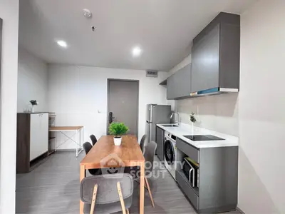 Modern kitchen with sleek cabinetry and dining area in open layout apartment.