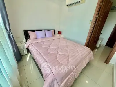 Cozy bedroom with pink bedding and air conditioning, perfect for relaxation.