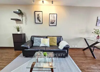 Stylish living room with modern decor, leather sofa, and glass coffee table in a cozy apartment.