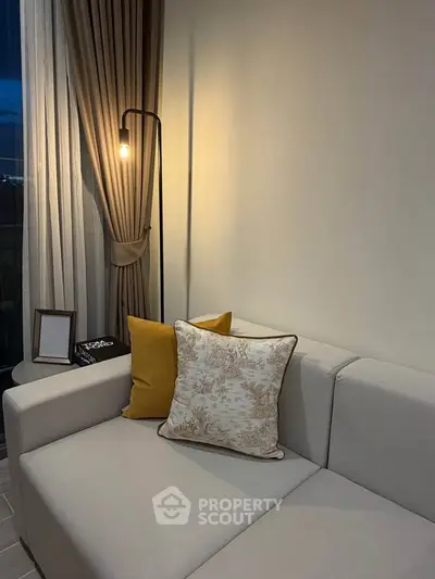 Cozy living room with elegant sofa and ambient lighting, perfect for relaxation.