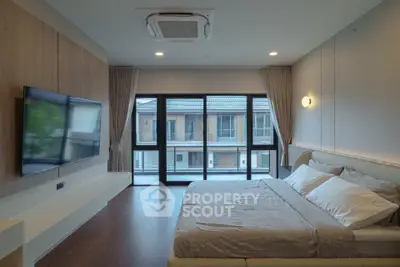 Spacious modern bedroom with large windows and stylish decor in a luxury home.