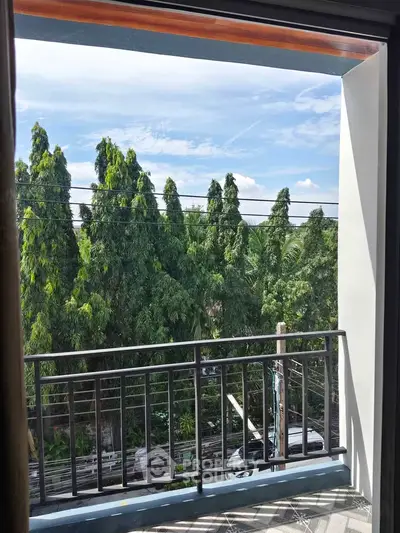 Charming balcony view with lush greenery and clear blue sky