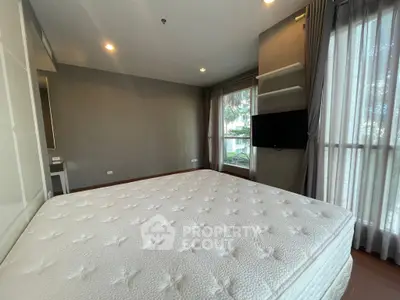 Spacious bedroom with large windows and modern decor in a stylish apartment.