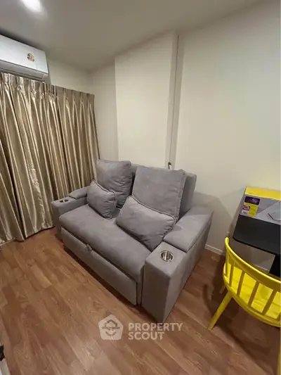 Cozy living room with modern gray sofa and vibrant yellow chair