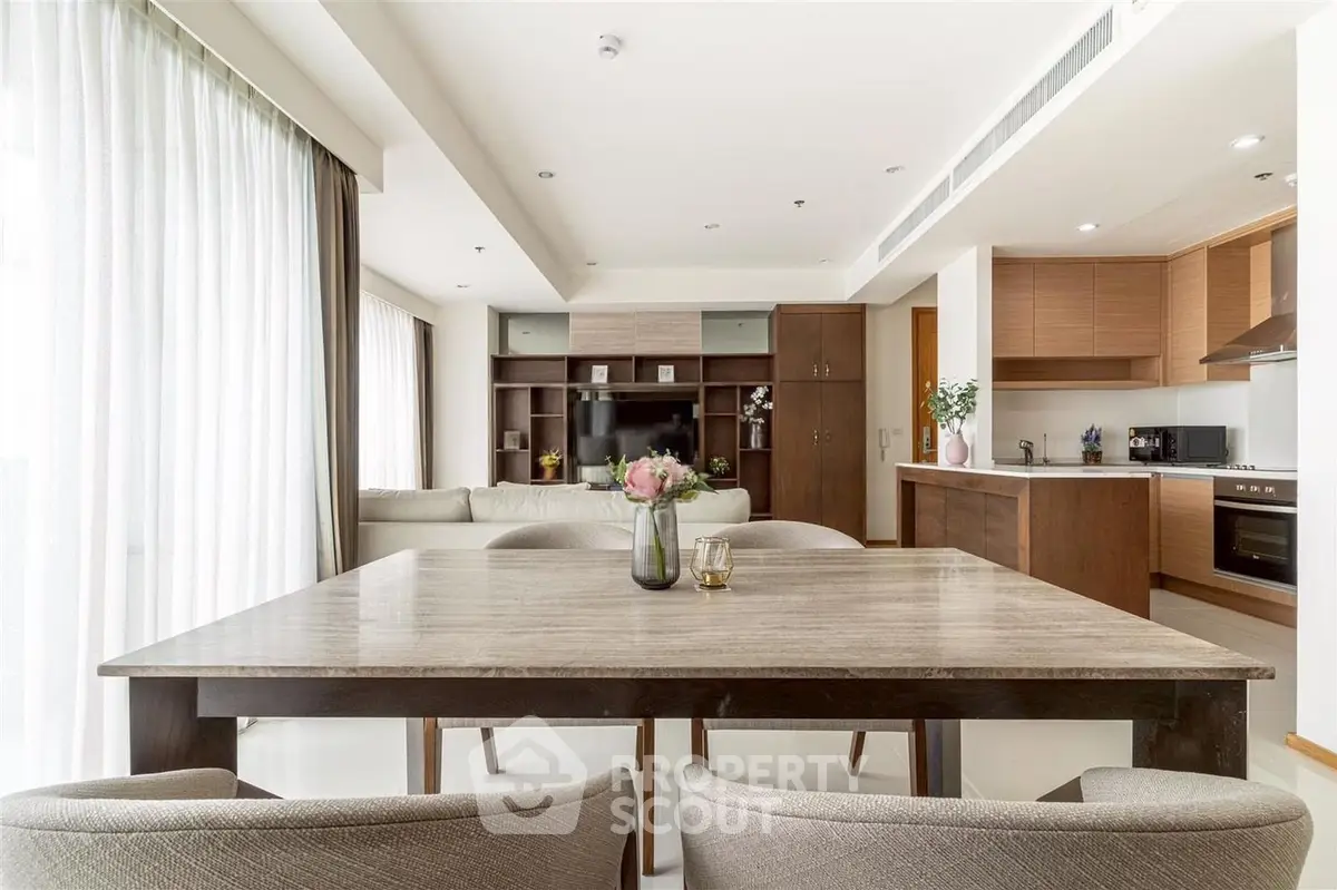 Spacious modern living room with open kitchen and elegant dining area, perfect for entertaining.
