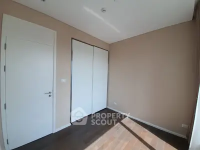 Spacious empty room with wooden flooring and ample natural light, perfect for customization.