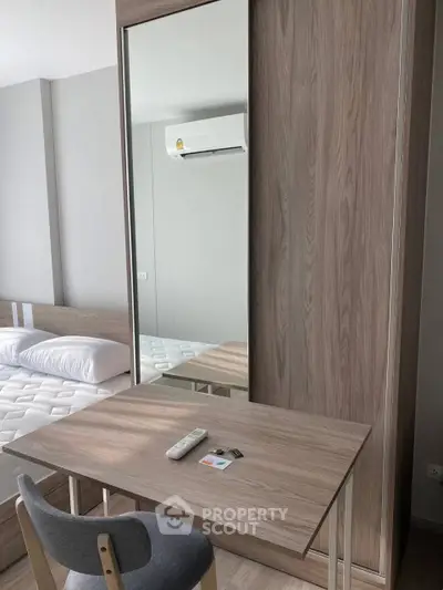 Modern bedroom with sleek wooden furniture and air conditioning, ideal for comfort and style.