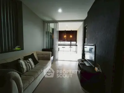 Modern living room with cozy sofa and stylish decor leading to a bright kitchen area.