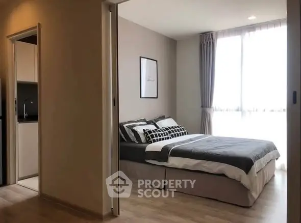 Modern bedroom with natural light and stylish decor in a cozy apartment.