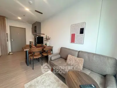 Modern living room with cozy sofa and dining area in open layout apartment.