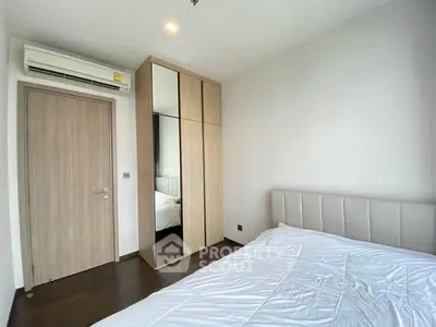 Modern bedroom with mirrored wardrobe and air conditioning unit