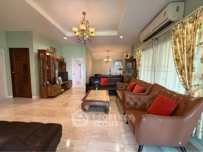 Spacious living room with elegant leather sofas, large windows, and stylish chandeliers in a modern home.