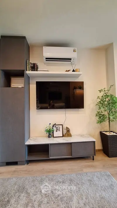 Modern living room with sleek TV unit and air conditioning, perfect for cozy relaxation.