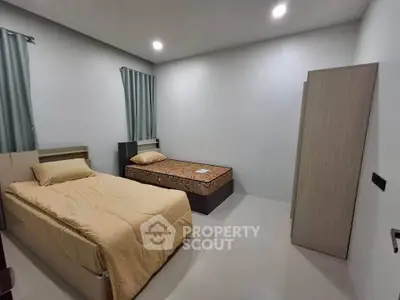 Cozy bedroom with twin beds and minimalist decor, perfect for comfortable living.