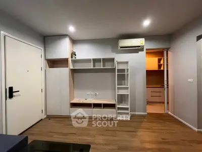 Modern living room with built-in shelving and air conditioning in a stylish apartment.