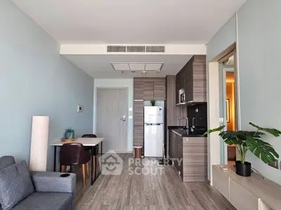 Modern living room with open kitchen, sleek furniture, and stylish decor in a contemporary apartment.