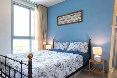 Charming bedroom with blue accent wall and large window offering natural light.