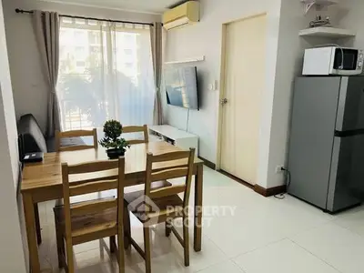 Modern living room with dining area, large window, and sleek appliances in a cozy apartment.