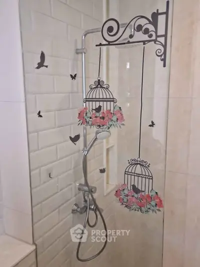 Stylish bathroom shower with decorative birdcage design on glass partition.