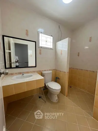Spacious bathroom with modern fixtures and tiled flooring in a real estate property.