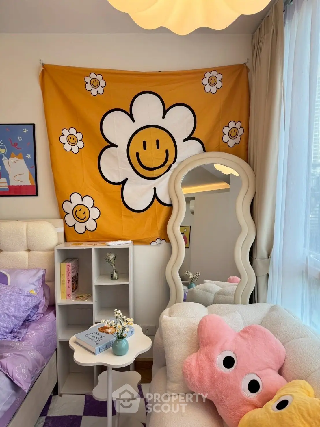 Charming bedroom with cozy decor and natural light, featuring a unique wavy mirror and playful flower tapestry.
