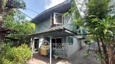 Charming two-story house with lush greenery and spacious outdoor area, perfect for family living.