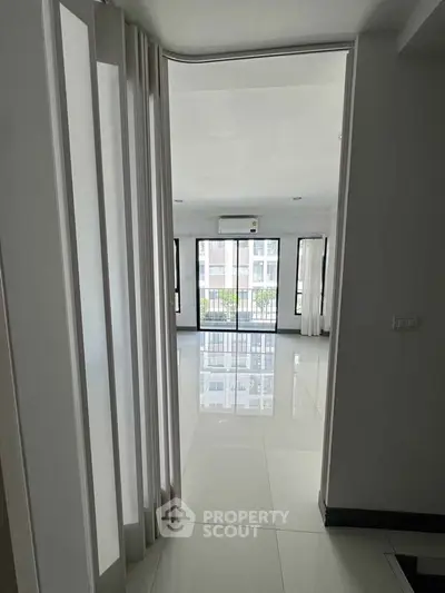 Spacious modern apartment with glossy tiled floors and large windows offering ample natural light.