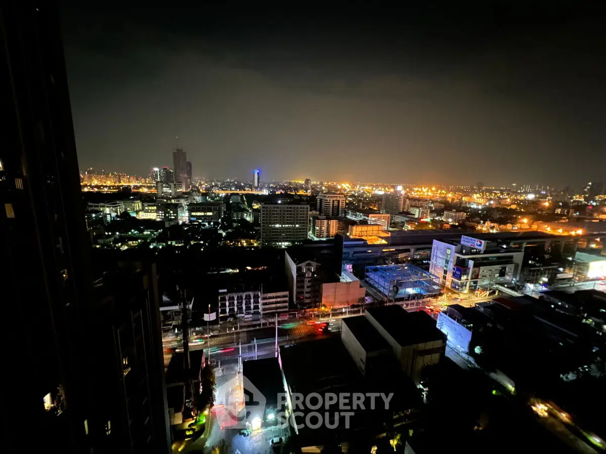 Stunning cityscape night view from high-rise building balcony, showcasing vibrant urban lights.