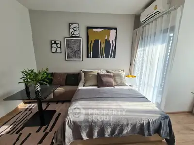 Modern bedroom with stylish decor and natural light, featuring a cozy bed and elegant artwork.