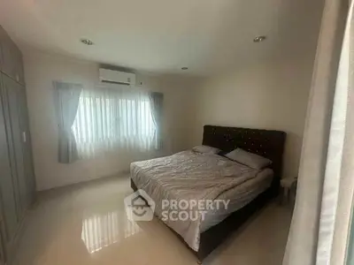 Spacious bedroom with large window and modern furnishings