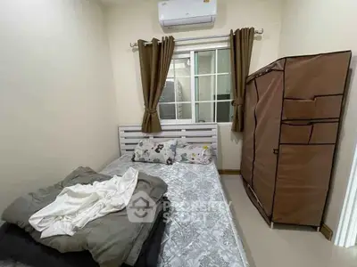 Cozy bedroom with compact layout, featuring a bed, window with curtains, and portable wardrobe.