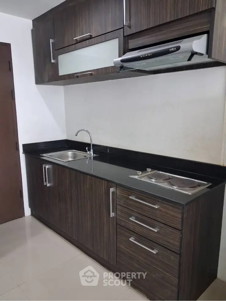 Modern kitchen with sleek cabinetry and built-in stove, perfect for culinary enthusiasts.