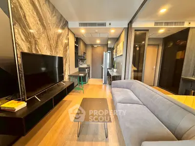Modern living room with sleek design, featuring a large TV and comfortable sofa in a stylish apartment.