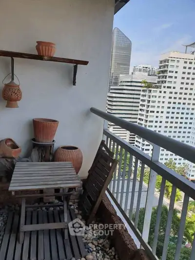 Charming balcony with city view, featuring rustic wooden furniture and decorative pots, perfect for relaxation.