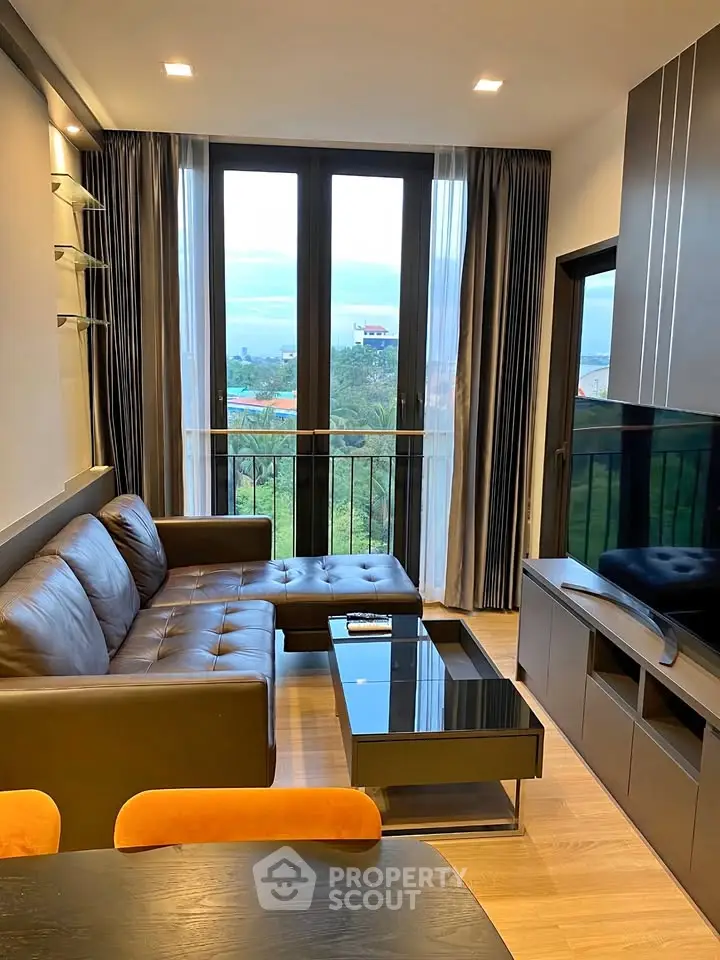 Modern living room with large windows and stylish furniture, offering a cozy and inviting atmosphere.