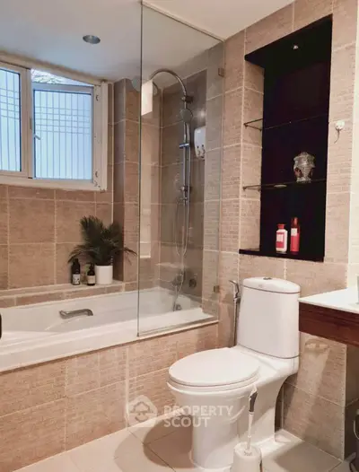 Modern bathroom with bathtub and shower in elegant tiled design