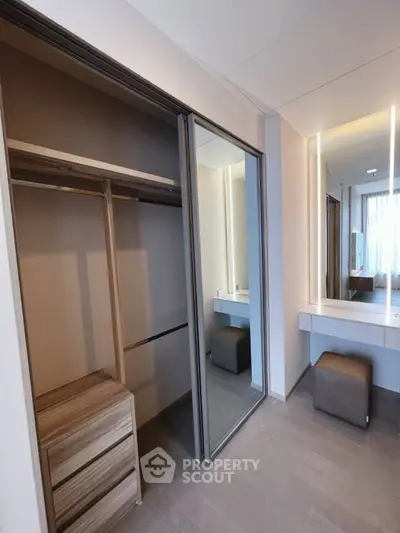 Modern bedroom with mirrored wardrobe and stylish vanity area