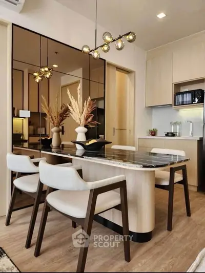 Modern dining area with elegant lighting and wooden furniture in a stylish apartment.