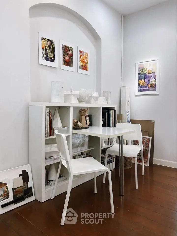 Charming study nook with white shelves and modern decor in cozy home setting.