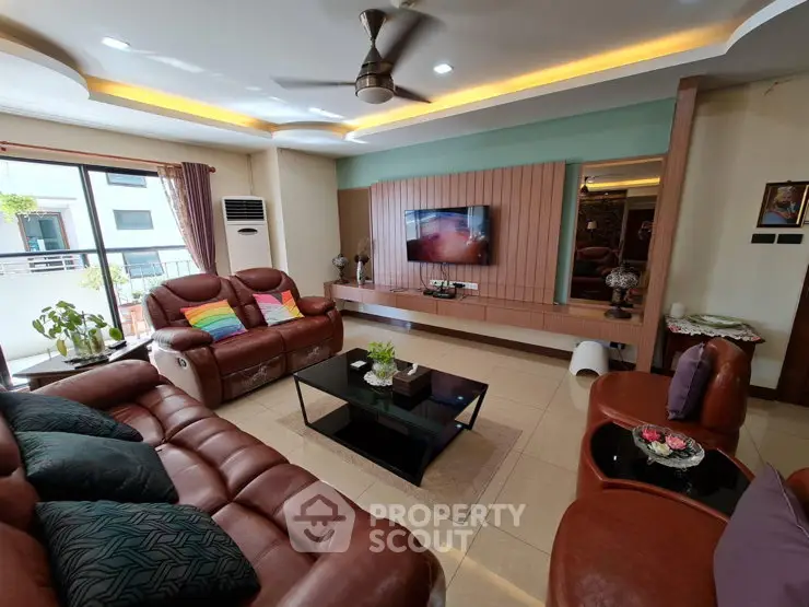 Spacious living room with modern decor and large leather sofas, perfect for relaxation and entertainment.
