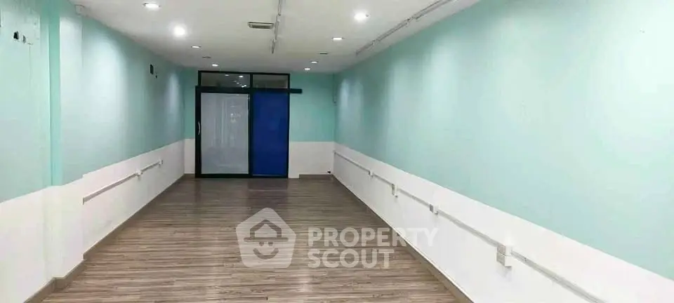 Spacious interior hallway with modern flooring and soft lighting, ideal for commercial or residential use.
