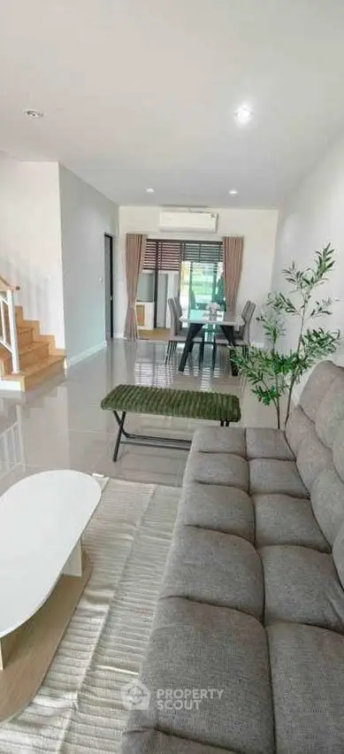 Spacious modern living room with stylish furniture and open dining area, perfect for family gatherings.