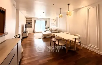 Spacious open-plan living and dining area with modern decor and wooden flooring.